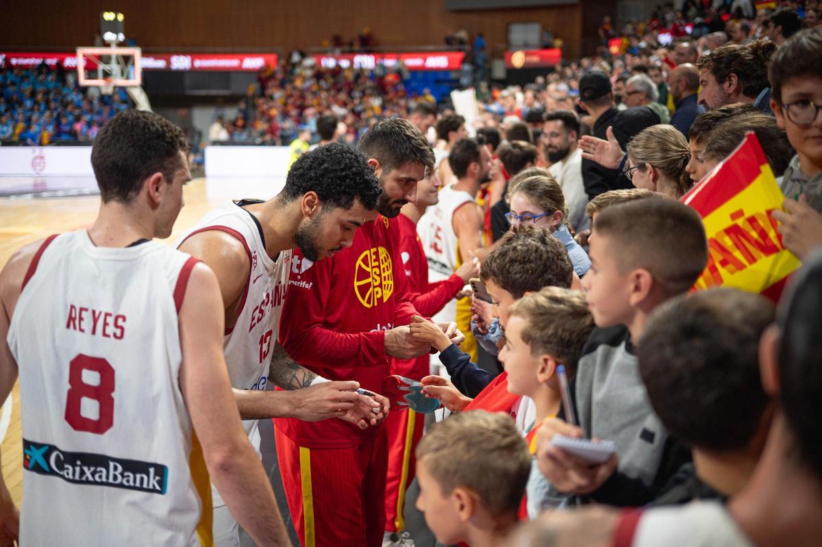 Los jugadores de la selección firman autógrafos al terminar el partido.