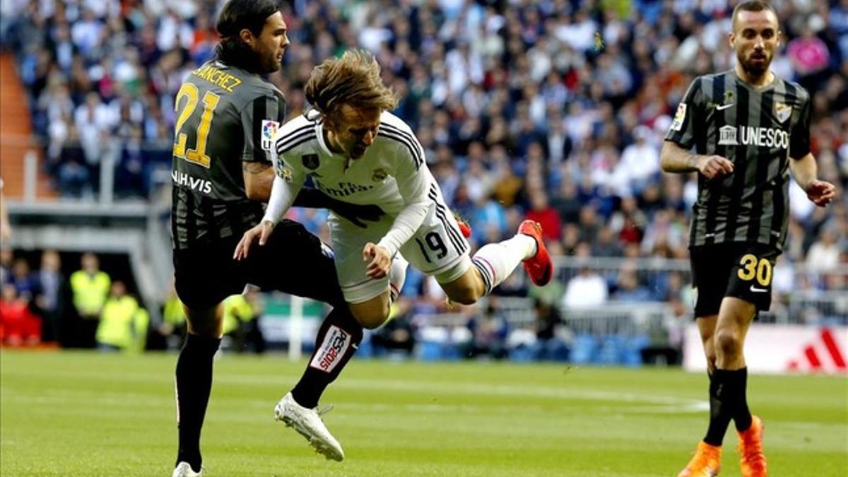 Sergio Sánchez hace saltar por los aires a Modric, durante el Real Madrid-Málaga.