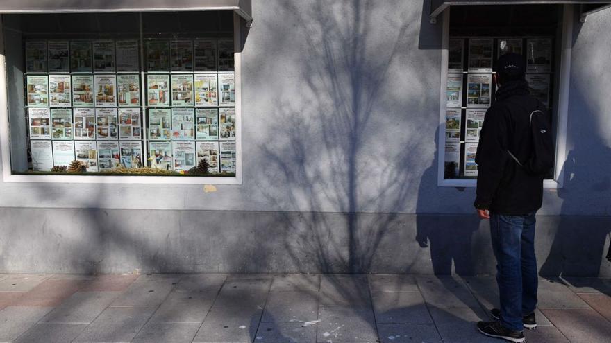 Un joven observa la oferta de pisos en una inmobiliaria de A Coruña. |   // VÍCTOR ECHAVE