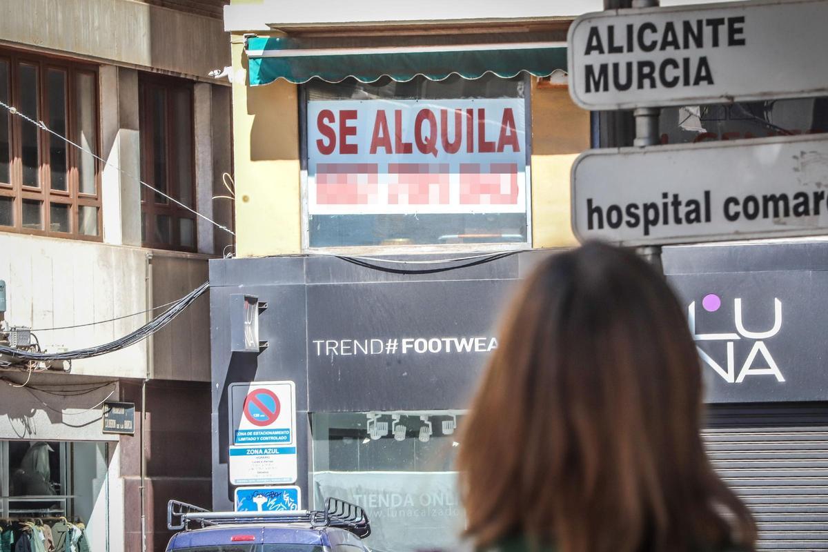 Una mujer mira un cartel de &quot;Se alquila&quot;