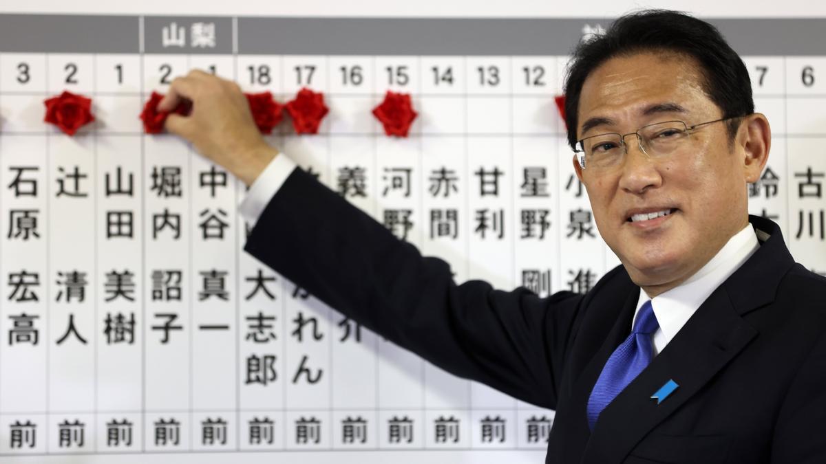 El primer ministro de Japón y líder del gobernante Partido Liberal Democrático, Fumio Kishida, hace un gesto mientras coloca rosetones con los nombres de los candidatos a las elecciones generales en un tablero en la sede del partido en Tokio, Japón, el 31 de octubre. 2021.