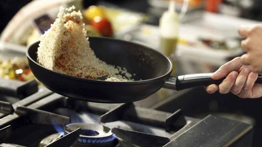 Un cocinero prepara un plato para sus comensales.