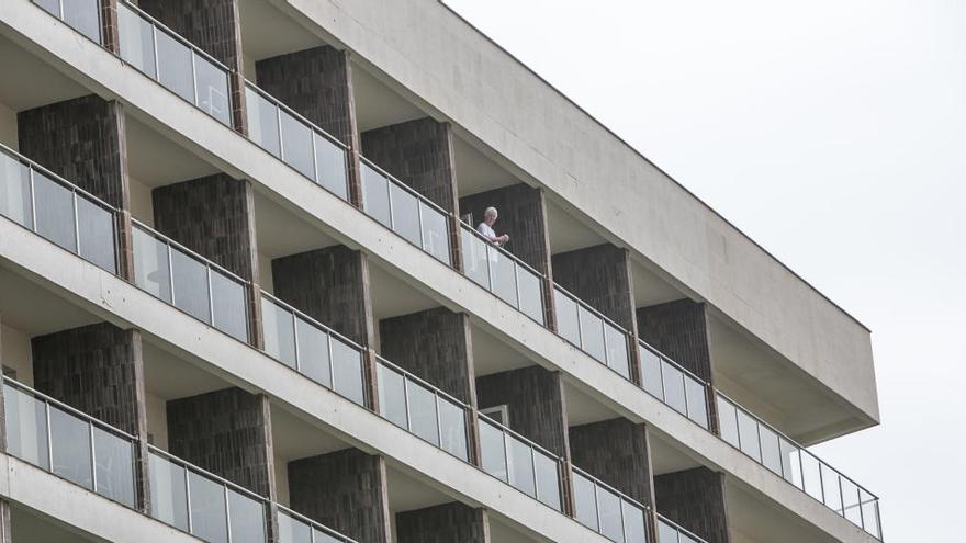 Un turista asomada a la terraza de su habitación en un hotel de Alicante