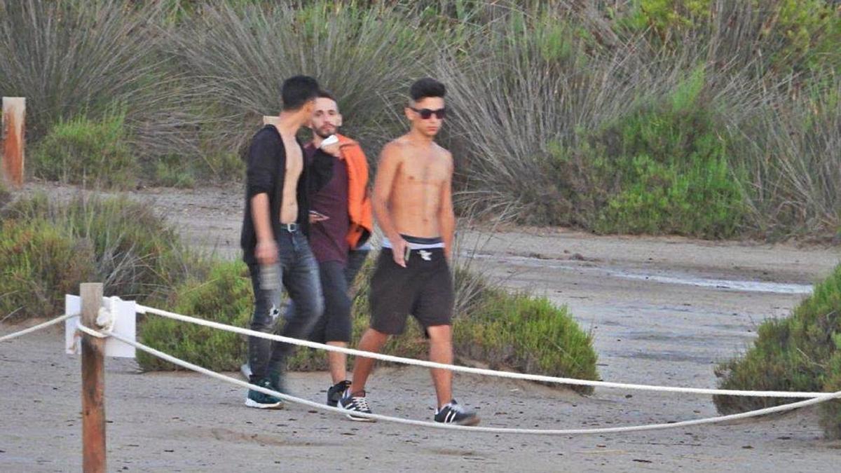 Tres jóvenes en el interior de la zona acotada para proteger la anidación de aves. | AA.VV. DEHESA - EL SALER