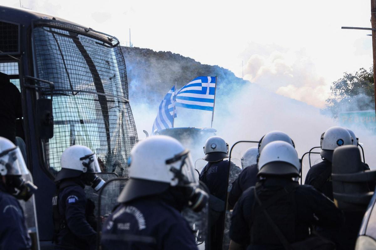 Riots police throw tear gas at farners near Heraklion International Airport, as police block the main access road in Heraklion, on the island of Crete, on December 8, 2025. Farmers on Crete on Monday clashed with riot police near the Greek islands international airports in a burgeoning protest wave related to an EU subsidy probe. (Photo by Costas METAXAKIS / AFP)