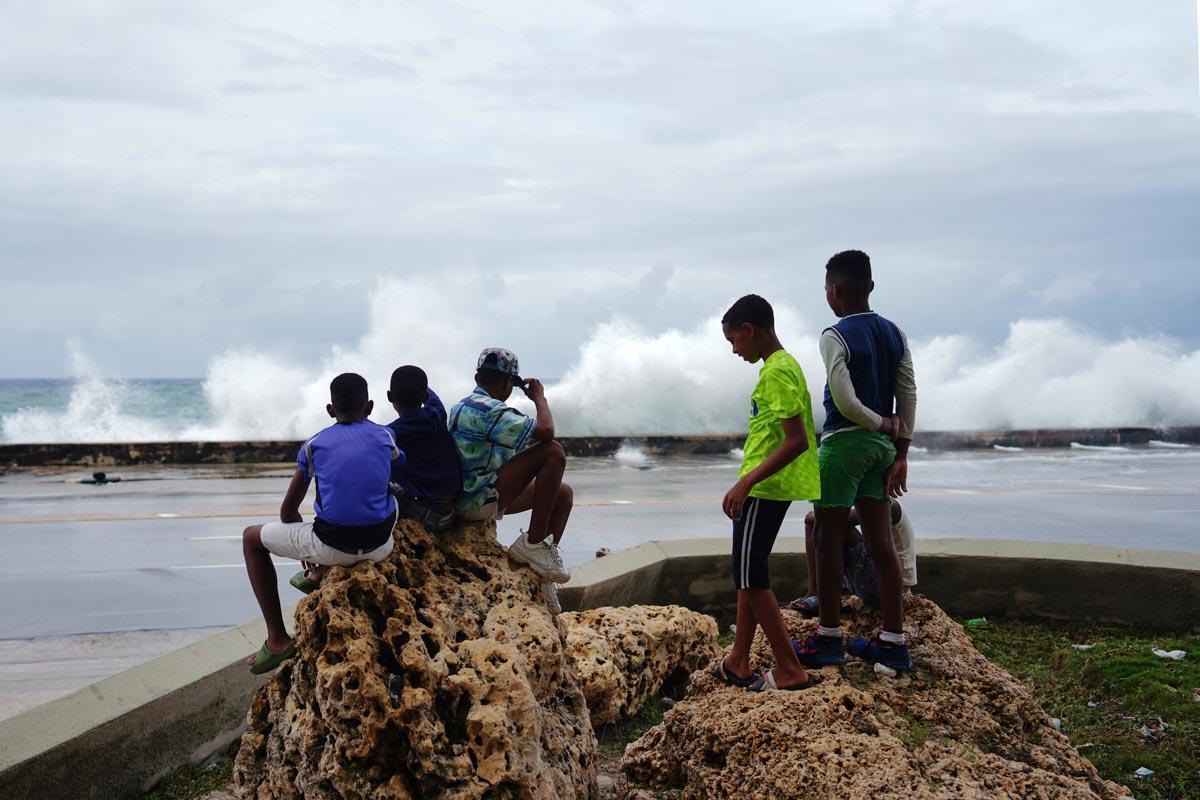 Unos niños observan las olas rompiendo en el paseo marítimo tras el paso del huracán Ian en La Habana, Cuba.