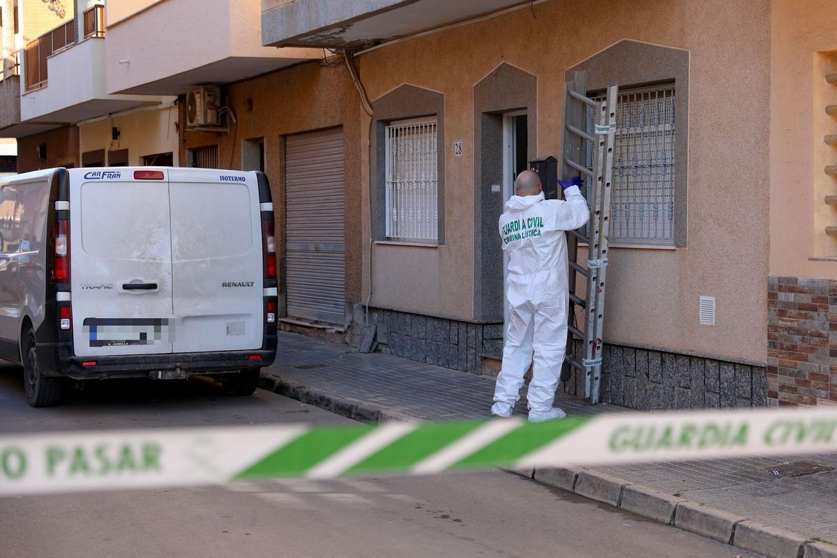 Un agente de criminalística sostiene la escalera utilizada en el crimen.