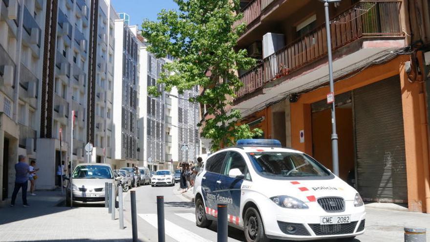 Un cotxe dels Mossos al carrer on hi ha el bloc de pisos on han trobat la nena