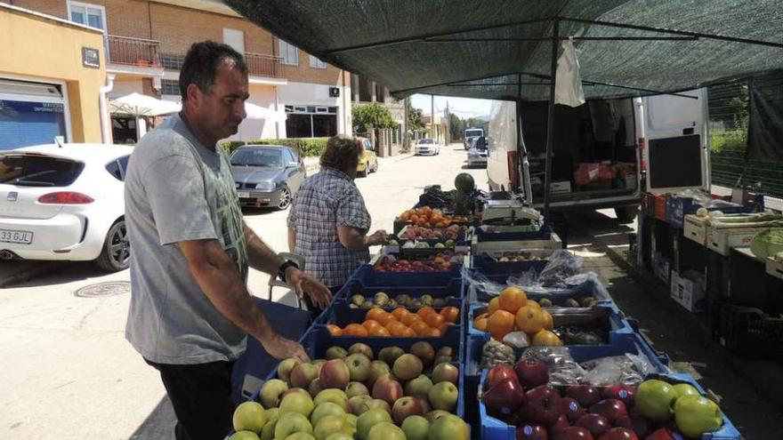 Varias personas en el mercado de Santibáñez, instalado en la calle Constitución donde se va a actuar en la mejora del pavimento.