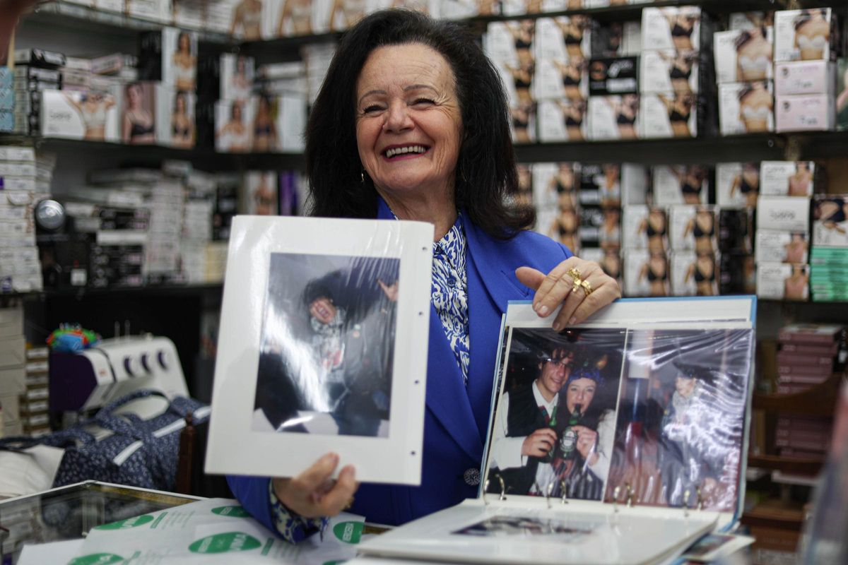 Margarita Ribas, en su tienda, muestra unas fotos de sus hijos disfrazados.
