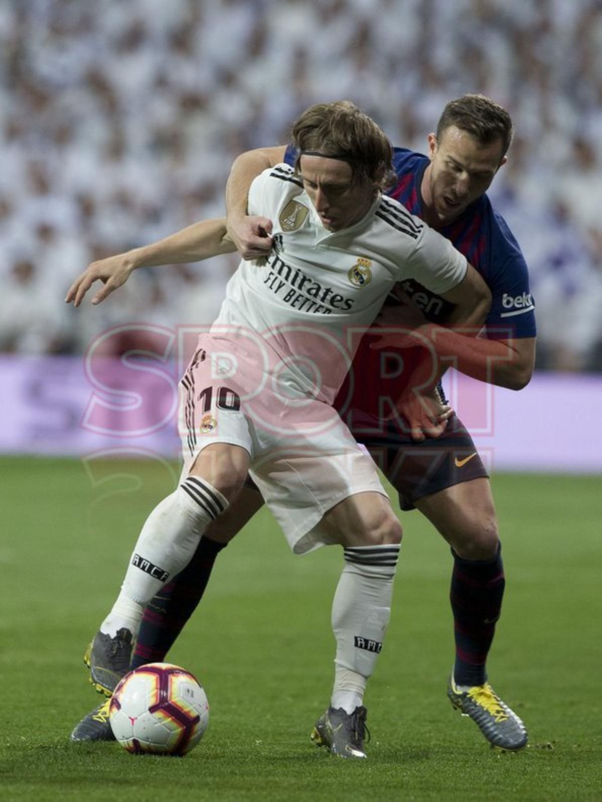Arthur Melo y Luka Modric durante el partido entre el Real Madrid y el FC Barcelona en el Estadio Santiago Bernabéu de jornada 26 de La Liga.