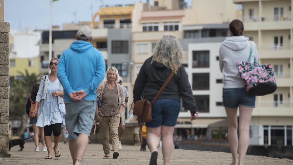 Un grupo de turistas pasea por una avenida de la costa de Tenerife.