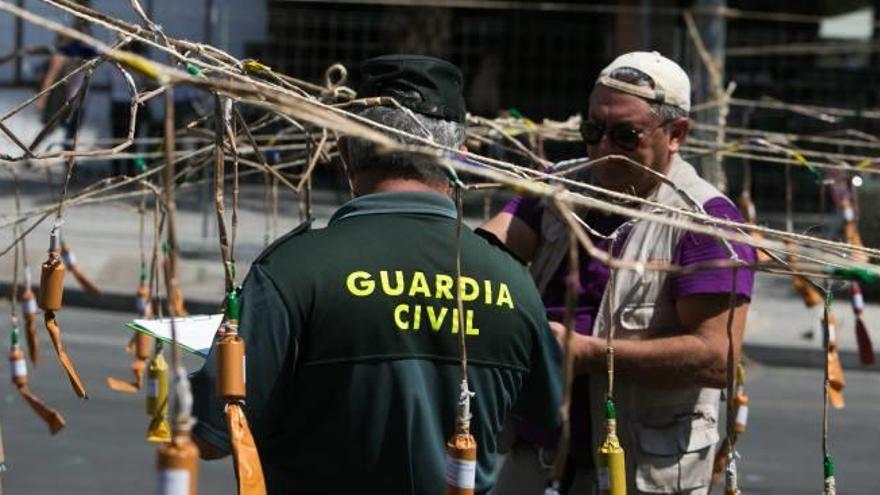 Un agente de la Guardia Civil inspecciona los artefactos explosivos de la mascletà del jueves acompañado de un pirotécnico.