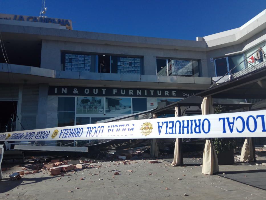 El viento derriba un cartel de grandes dimensiones sobre la terraza de un centro comercial en Orihuela Costa sin causar víctimas