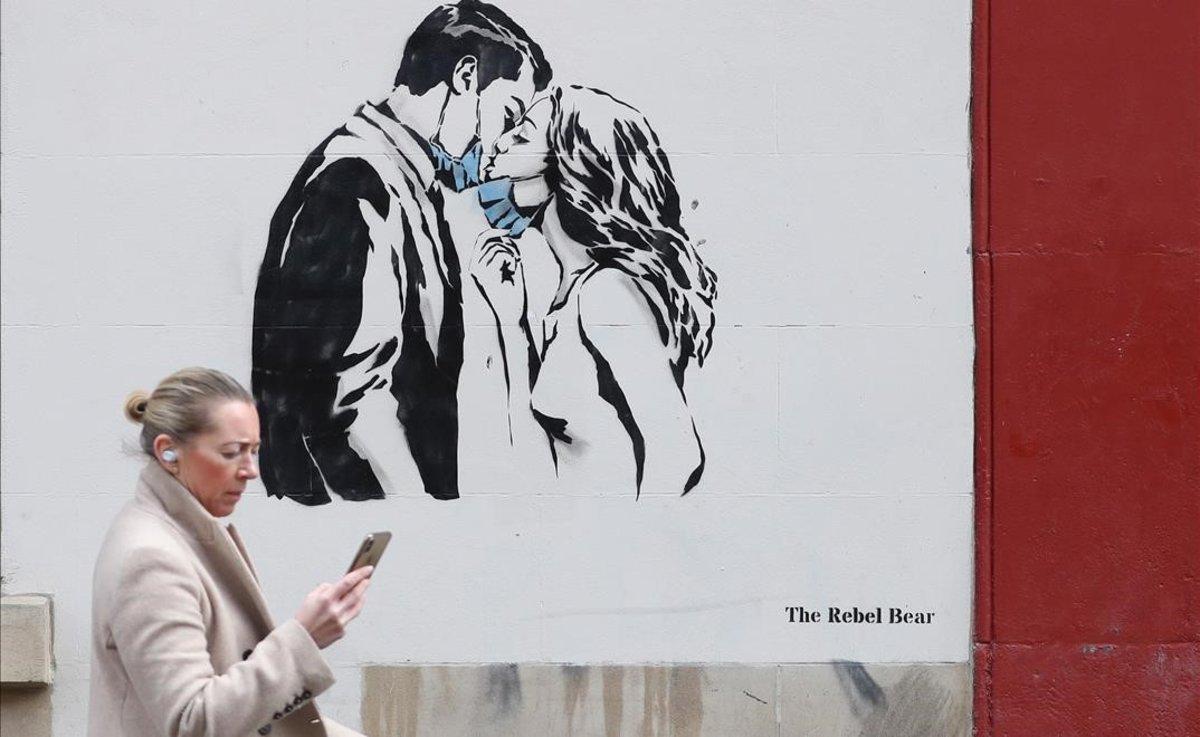 Una pareja con mascarilla que se da un beso es la protagonista de un mural en Glasgow, Escocia.