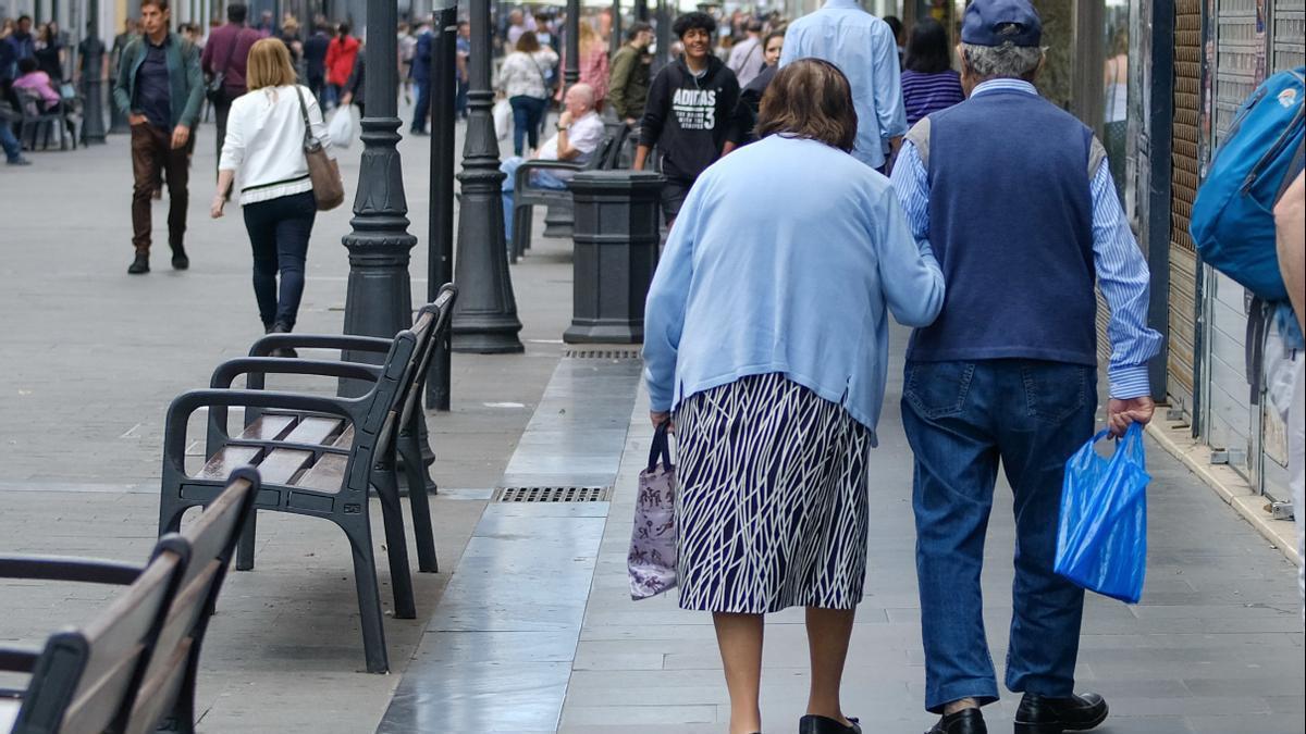 Una pareja de persona mayores pasea por la calle Triana de la capital grancanaria