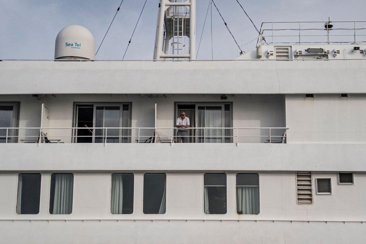 Esta vista aérea muestra a un pasajero observando cómo el personal de salud invisible ayuda a los pacientes a subir a un barco desde el crucero MV Hondius, mientras está estacionario en el puerto de Praia, la capital de Cabo Verde, el 6 de mayo de 2026. Esta vista aérea muestra a un pasajero observando cómo el personal de salud invisible ayuda a los pacientes a subir a un barco desde el crucero MV Hondius, mientras está estacionario en el puerto de Praia, la capital de Cabo Verde, el 6 de mayo de 2026.