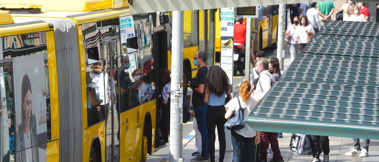 Usuarios del transporte público se suben a un vehículo de Guaguas Municipales en la estación de San Telmo.