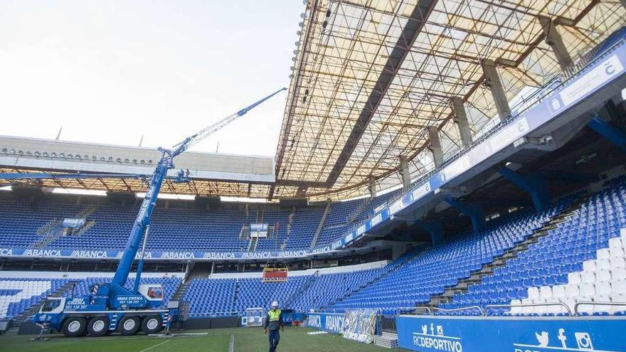 Trabajos de reparación de una de las cubiertas del estadio de Riazor con una grúa.