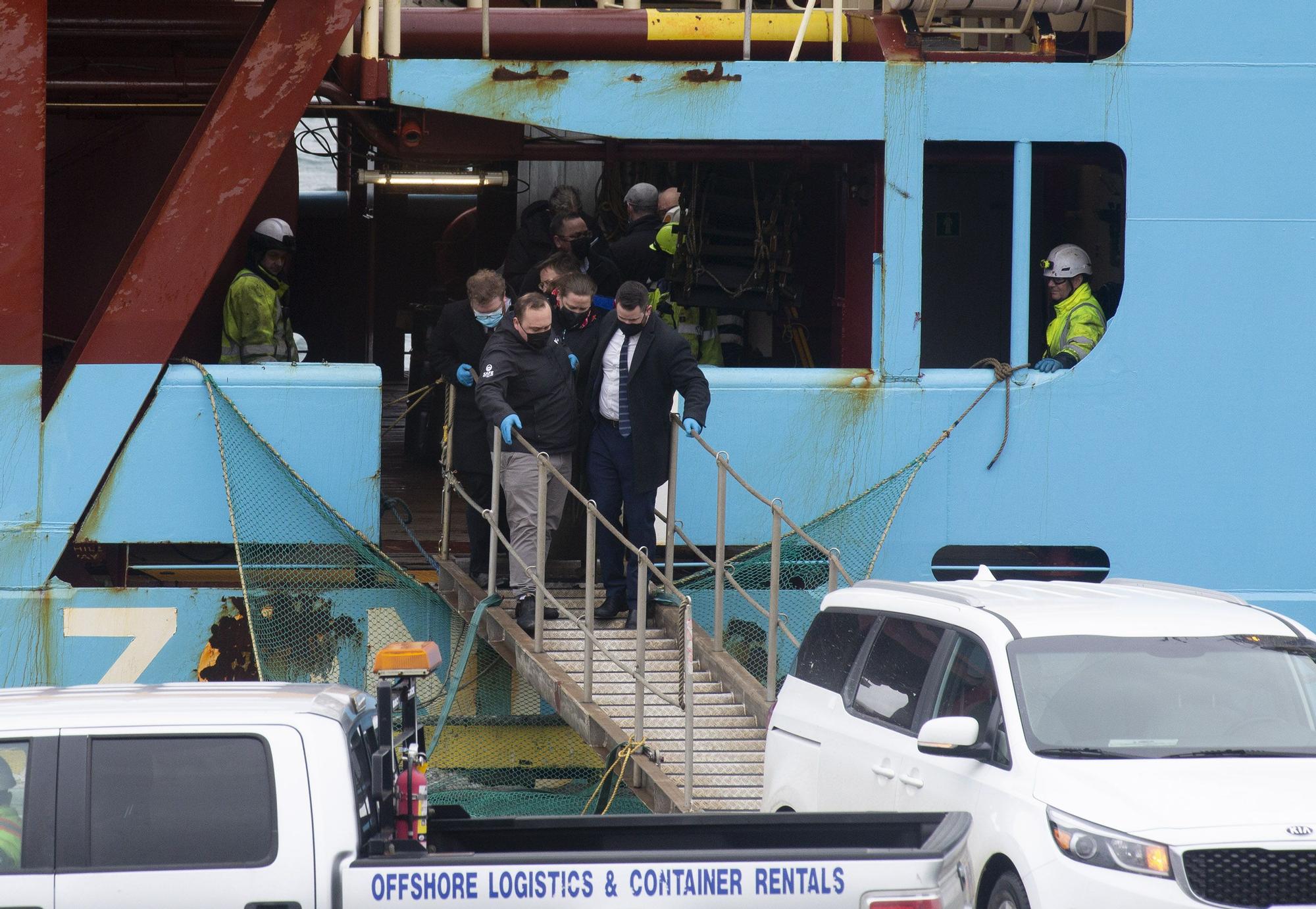 Personal forense transporta uno de los dos cuerpos de los pescadores naufragados en Terranova que hoy han sido transportados en el buque ‘Nexus’ que ha llegado al Puerto de San Juan de Terranova, a 18 de febrero de 2022, en San Juan, Terranova (Canadá).