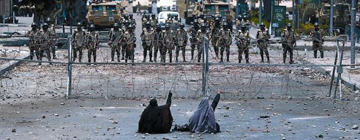 Dues seguidores de Mursi protesten a terra davant dels soldats, ahir. Dues seguidores de Mursi protesten a terra davant dels soldats, ahir.