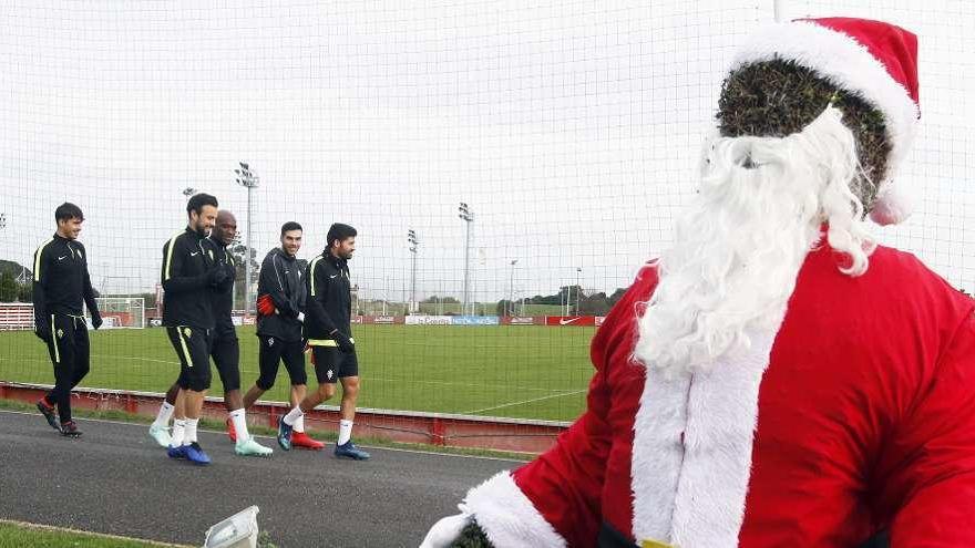 Los jugadores del Sporting, ante el Papá Noel situado frente a las oficinas del club en Mareo.