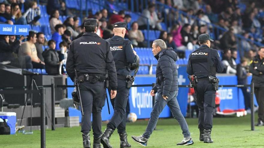 Óscar Cano, camina ayer entre varios policías en la banda de Riazor. |  // VÍCTOR ECHAVE