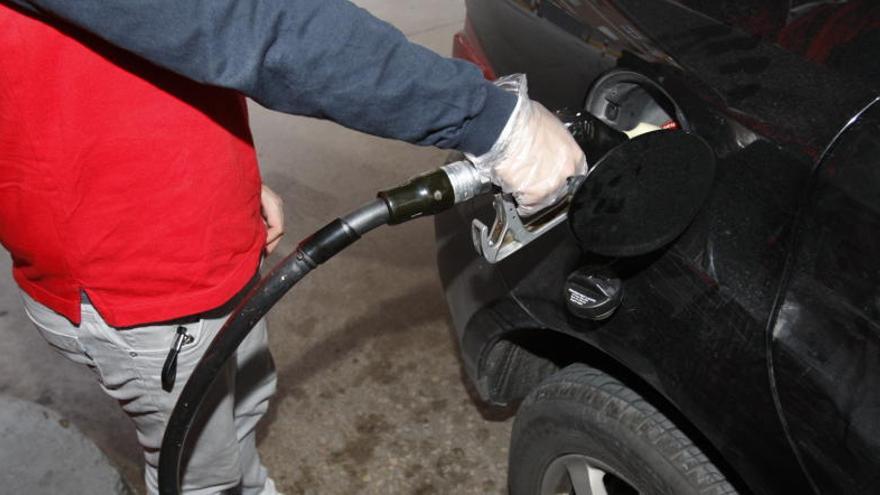 Un conductor resposta combustible en una gasolinera.