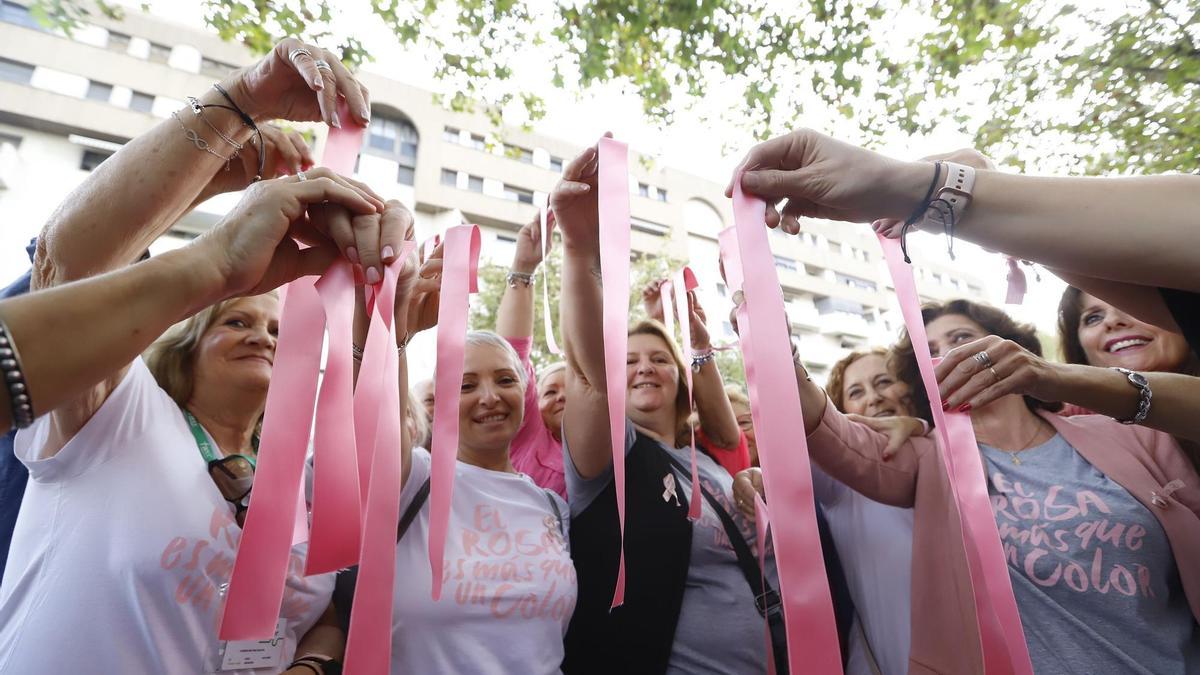 Un grupo de mujeres luce lazos rosas para concienciar sobre el cáncer de mama.