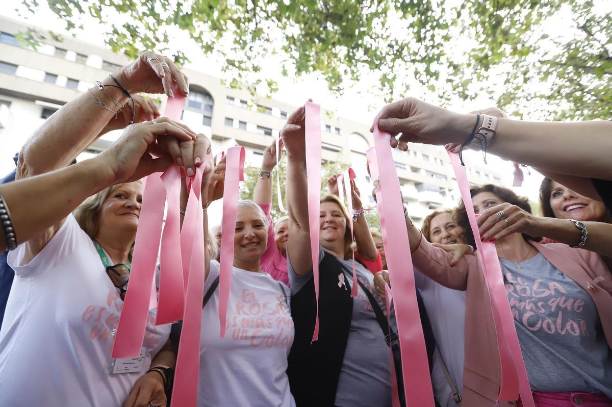 Un grupo de mujeres luce lazos rosas para concienciar sobre el cáncer de mama.