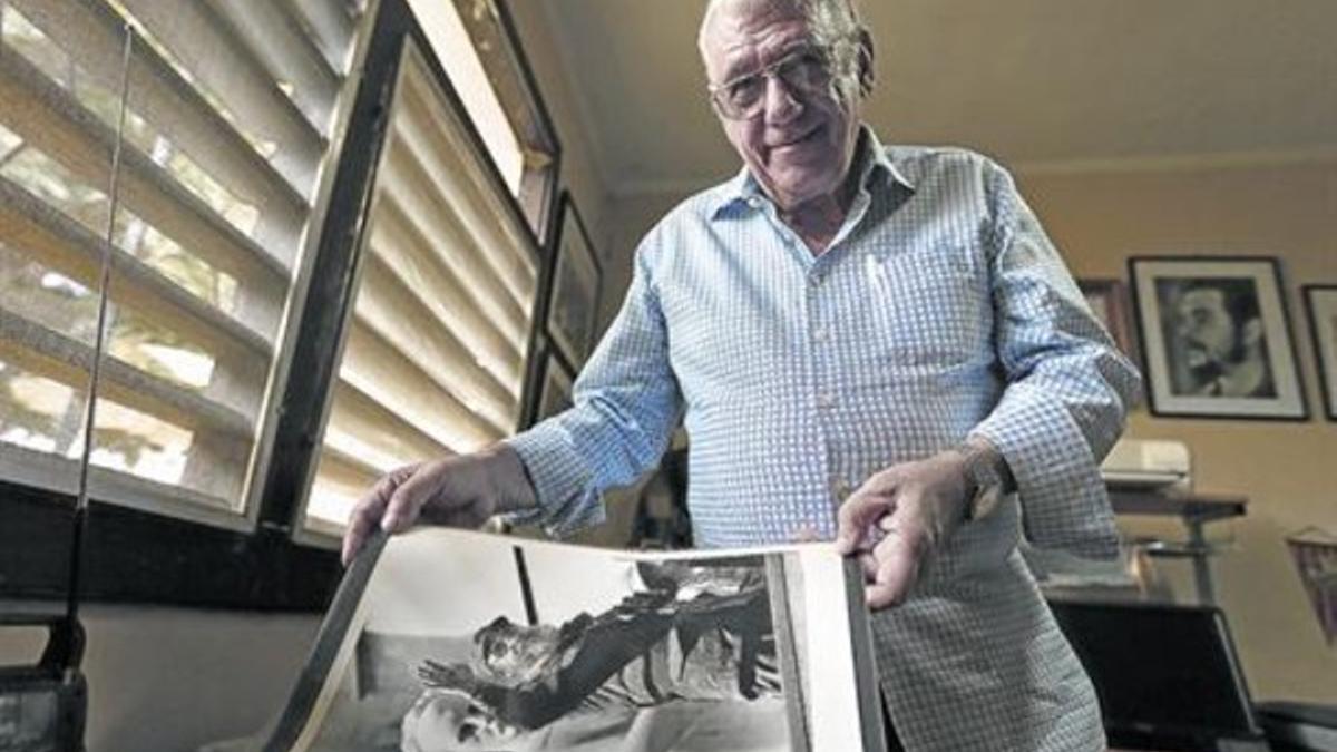 Jorge Oller, en el estudio de su casa, con una foto suya de Fidel y, detrás, en la pared, otra de Che Guevara.