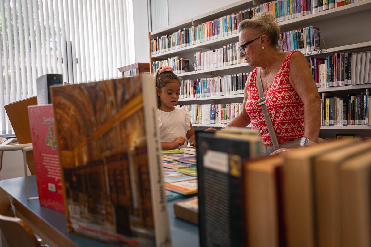 La pequeña Leire y su abuela buscan un libro en la Biblioteca Municipal de Santa Úrsula.