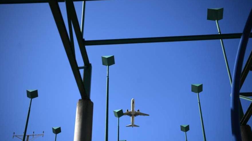 Un avión sobrevuela los postes del sistema ILS en la cabecera 21 de Alvedro.