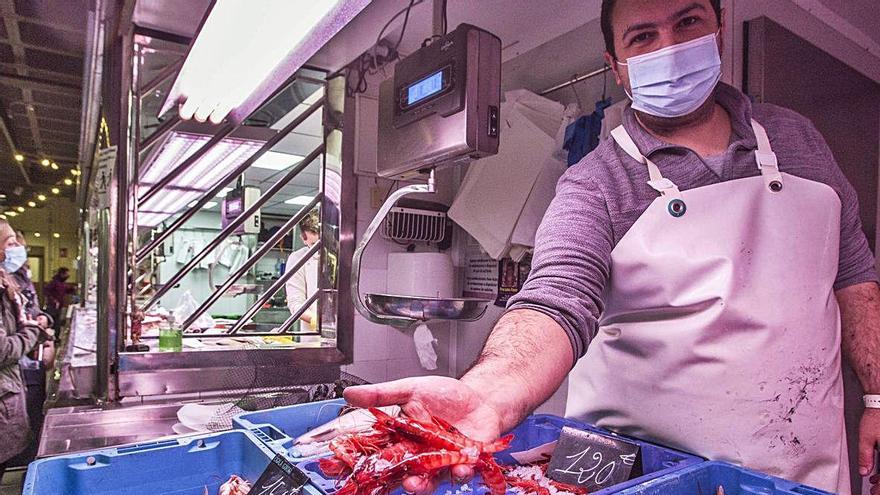 Dos de los vendedores de marisco que ofrecen gamba roja y cigalas en el Mercado Central de Alicante a 120 y 150 euros el kilo. Los crustáceos más caros se agotaron.