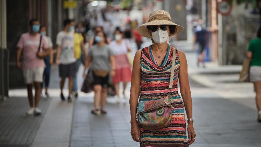 Una mujer camina con mascarilla por la calle Castillo de Santa Cruz de Tenerife.