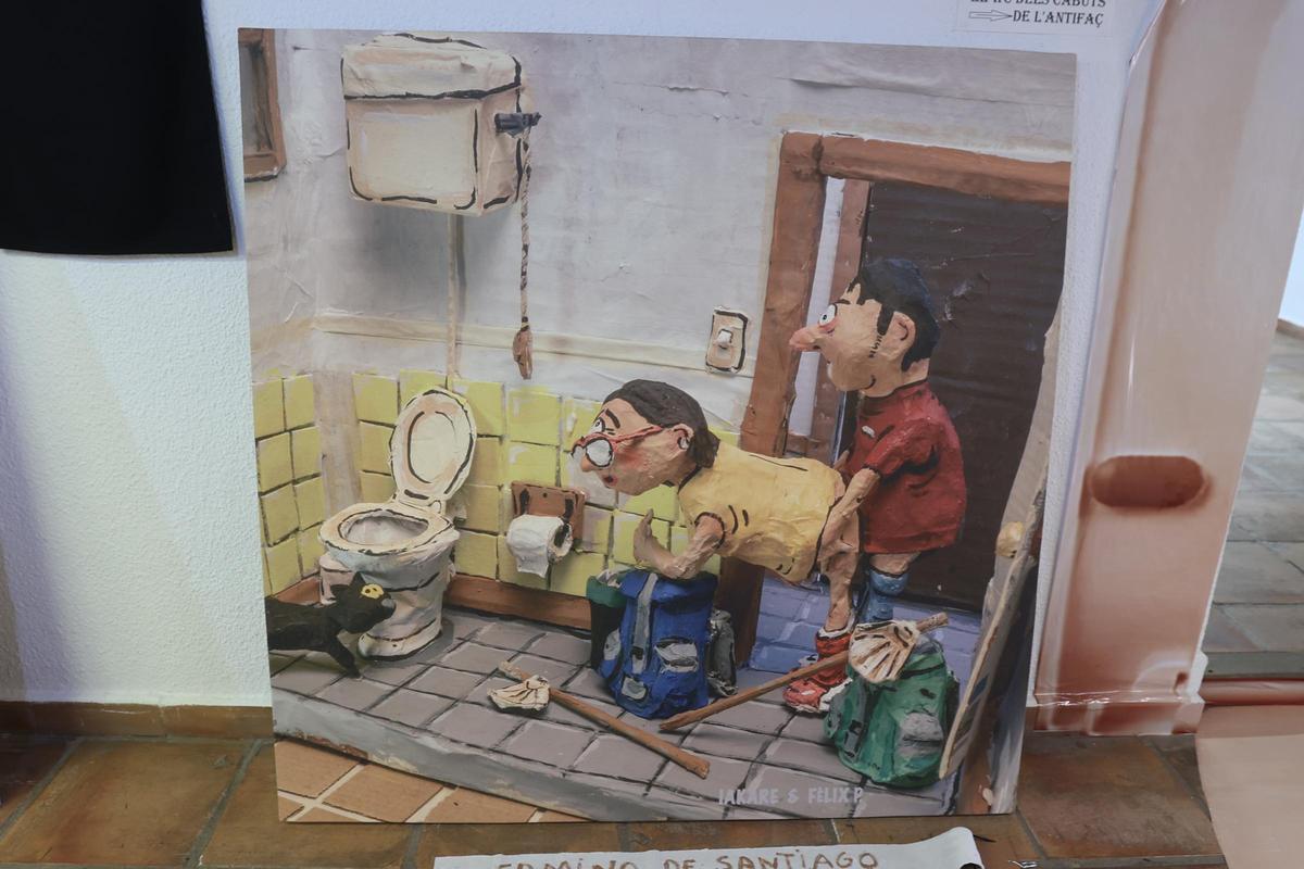 La imagen muestra a dos personas practicando sexo, con mochilas y los símbolos del Camino de Santiago.