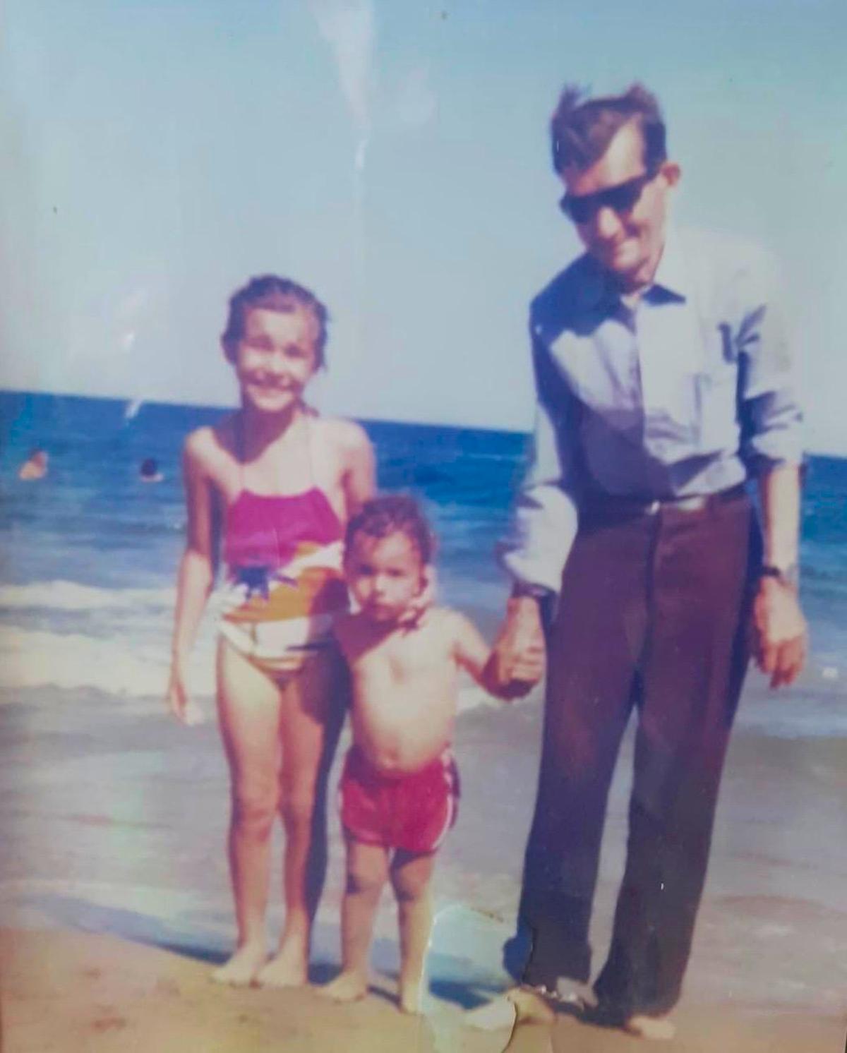 Paco Ureña, centro, con su hermana Beatriz, y su abuelo Paco, en la Playa de Terreros.
