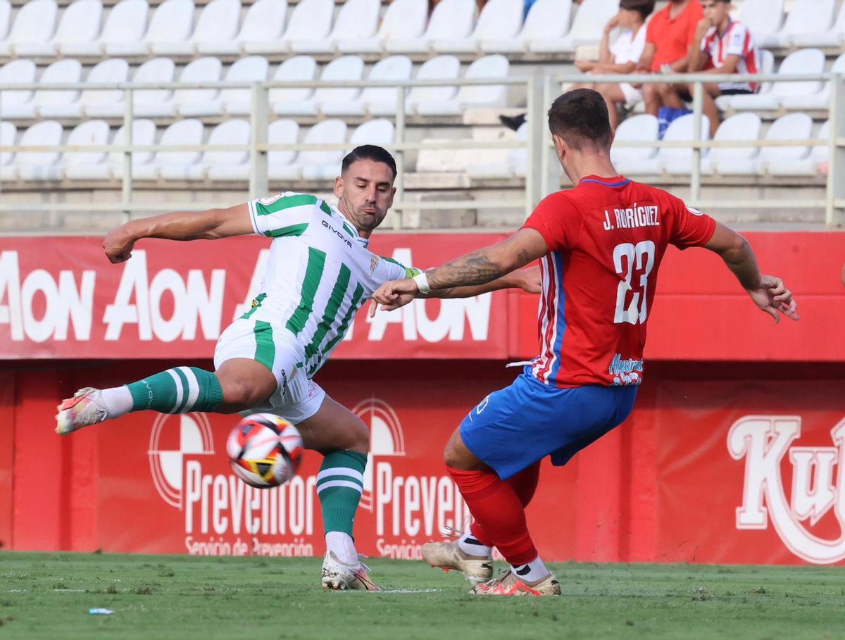 Kike Márquez golpea el balón ante Juan Rodríguez durante el encuentro del Córdoba CF en el Nuevo Mirador.