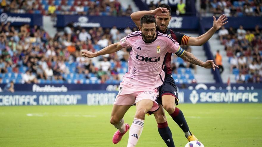 Bastón intenta hacerse con el balón bajo la presión de Postigo, capitán del Levante. | Área 11