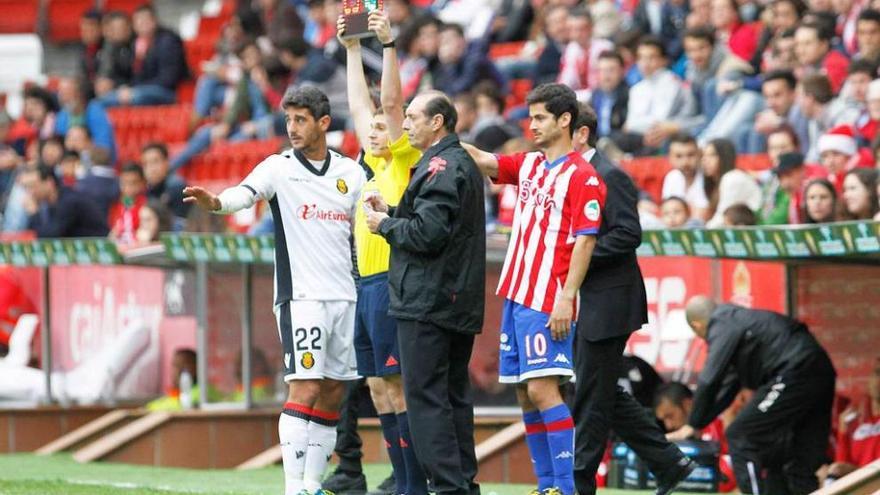 Quini, junto al cuarto árbitro, mientras se anuncian los cambios de Nacho Cases y Cendrós.