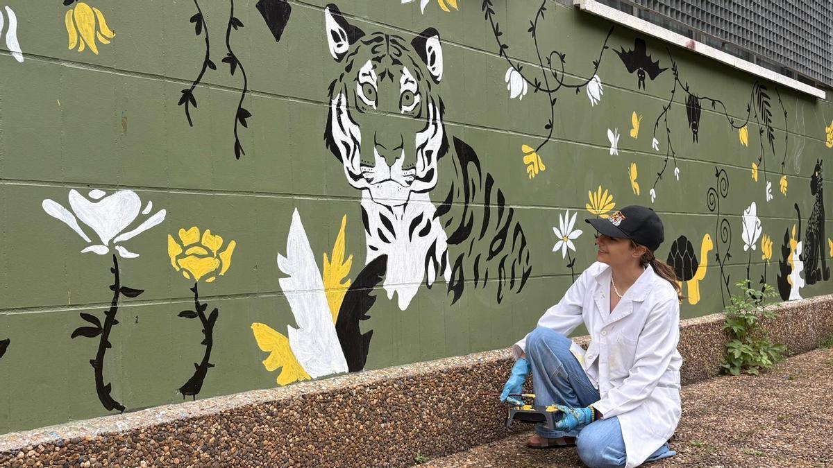 María Murias junto al tigre, el dibujo central del mural en el colegio Alejandro Casona.