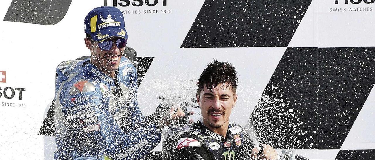 Joan Mir (izq.) y Maverick Viñales bañan con champagne a sus compañeros de equipo desde el podio del circuito Marco Simoncelli.