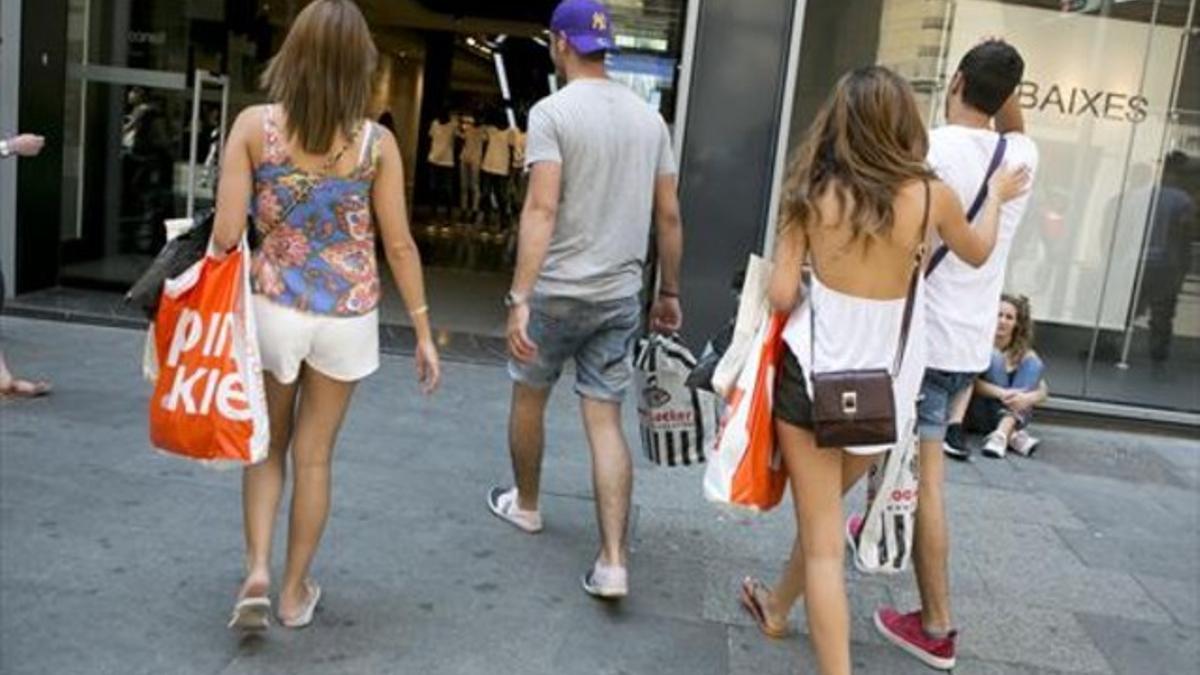 De tiendas 8 Turistas de compras por el centro de Barcelona.