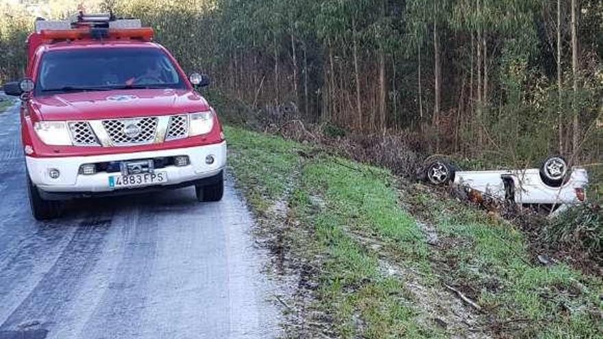 El vehículo volcado, junto a uno de Protección Civil.