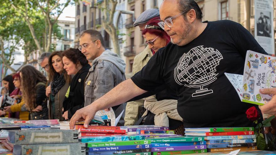 Varias personas compran libros en la celebración de Sant Jordi.