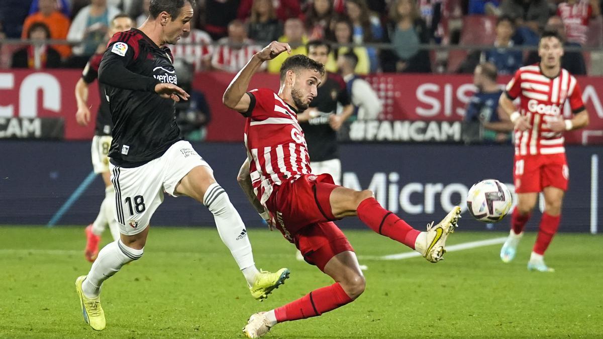 El delantero del Osasuna Kike García (i) y Santiago Bueno (d), del Girona, durante el partido