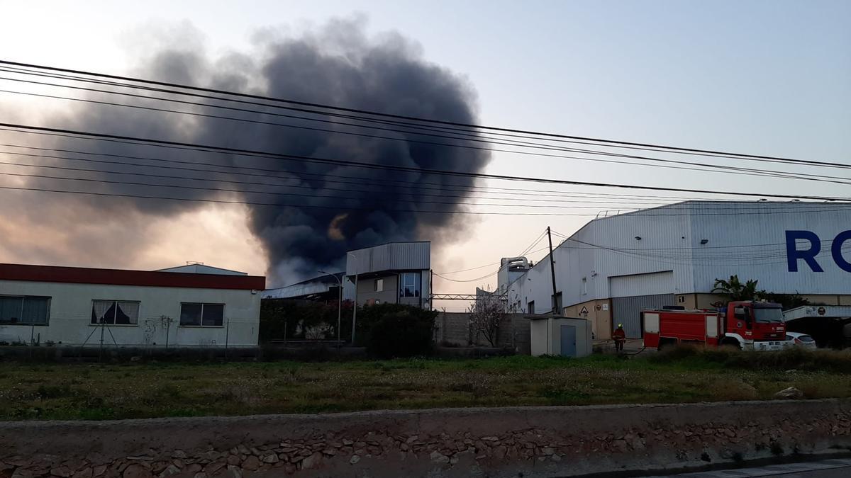 Una gran columna de humo sale de la fábrica incendiada en Náquera