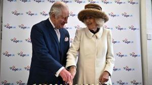Los reyes Carlos y Camila cortan un pastel durante un acto con voluntarios y usuarios de la organización benéfica Age UK, el pasado mes de marzo.