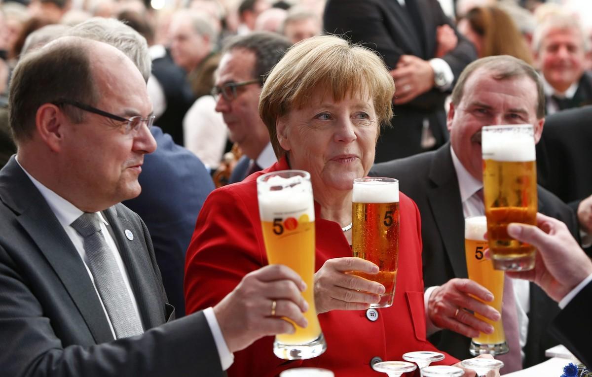 DOM04 INGOLSTADT (ALEMANIA), 22/04/2016.- La canciller alemana Angela Merkel (c), junto al ministro de Agricultura y Alimentación alemán, Christian Schmidt (i), brinda con cerveza mientras participa en una ceremonia con motivo del 500 aniversario de la Ley de la pureza de 1516, en Ingolstadt, Alemania, hoy, 22 de abril de 2016. La ley, considerada la primera regulación legal de un alimento, establece que la cerveza sólo debe elaborarse a partir de agua, cebada malteada y lúpulo. EFE/Michaela Rehle