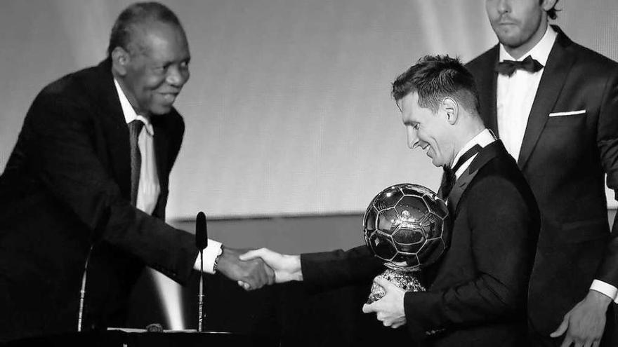 El presidente en funciones de la FIFA, Issa Hayatou, entrega el Balón de Oro a Messi el año pasado.